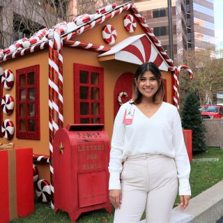 Woman in front of gingerbread house