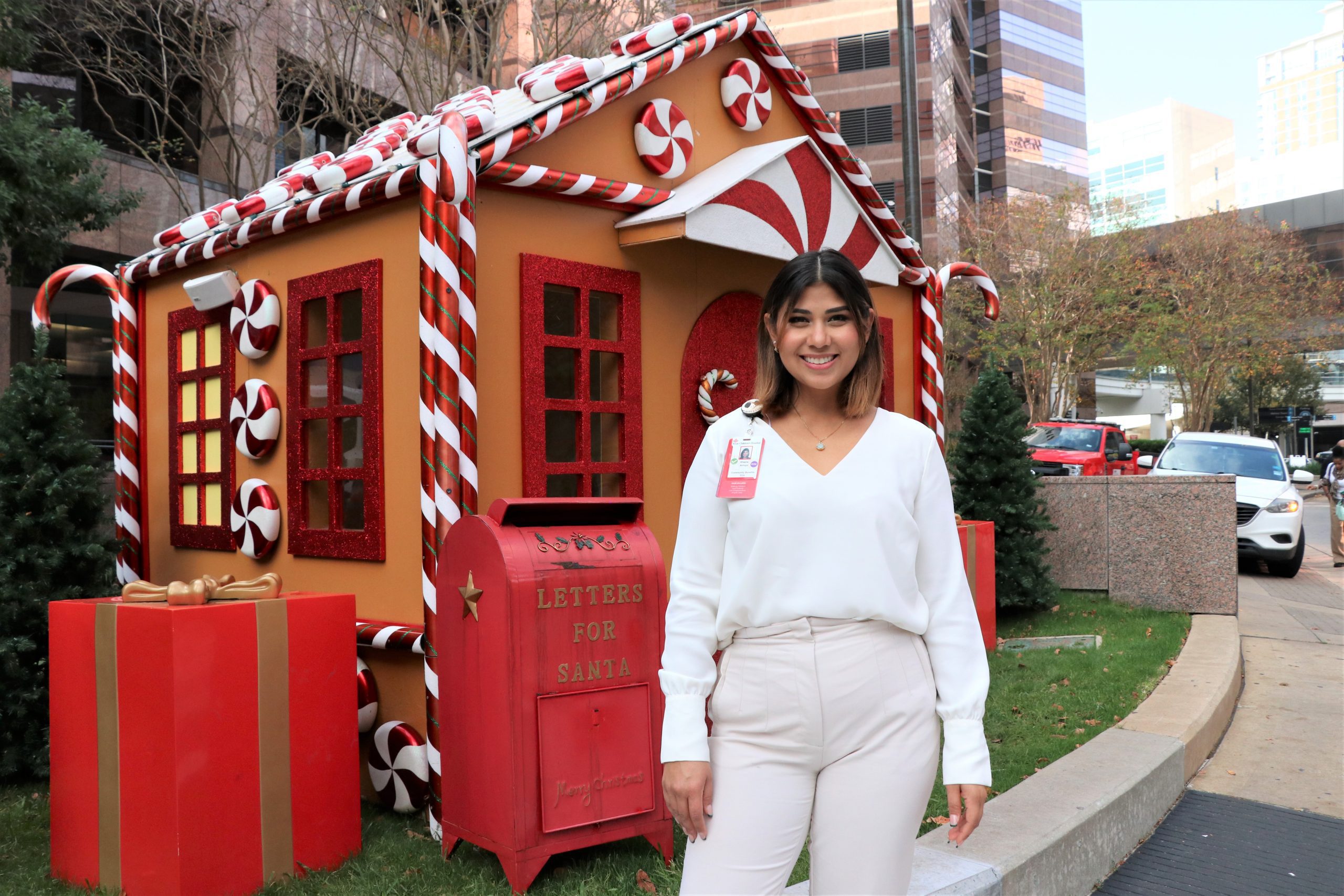 Woman in front of gingerbread house